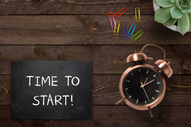 istock Alarm clock next to slate plate with text 