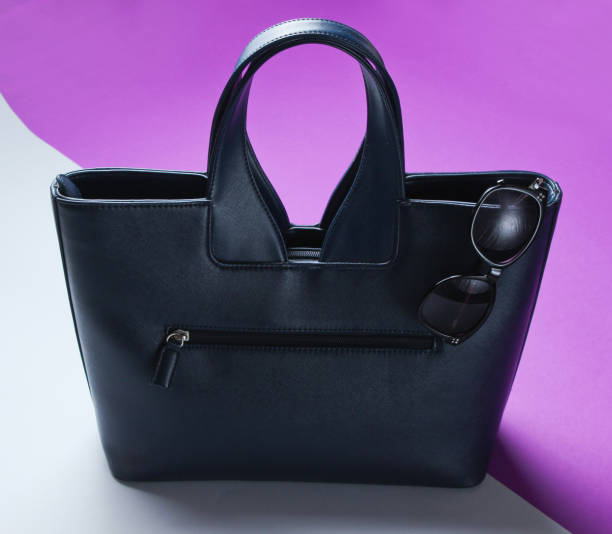 istock Leather bag, sunglasses on gray-purple background. 1158033501