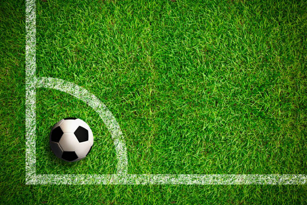 Overhead view on isolated soccer ball in field with white markings on grass. Dark vignette at edges.