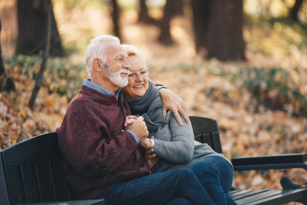 istock Happy autumn senior couple on park bench 1158033549