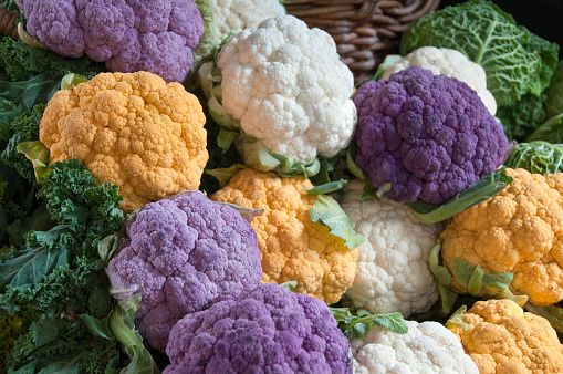 Market stall with fresh multicoloured cauliflowers and cabbage for sale