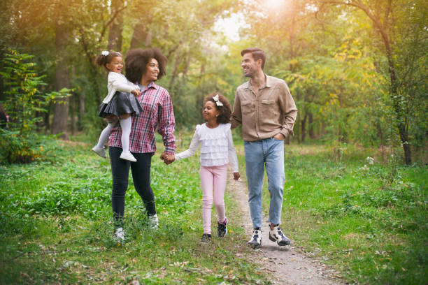 familia feliz caminando por un camino en el bosque - family grass toddler african descent fotografías e imágenes de stock