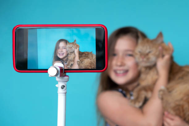 fille posant devant l'appareil-photo avec le chat - pointer stick audio photos et images de collection