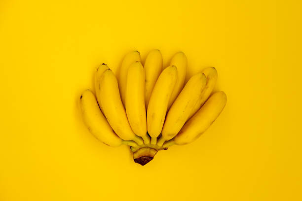 istock Bunch of bananas on blue backdrop top view 1158038668