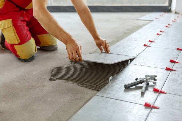 ceramic tiles. tiler placing ceramic wall tile in position over adhesive with lash tile leveling system - instalando imagens e fotografias de stock