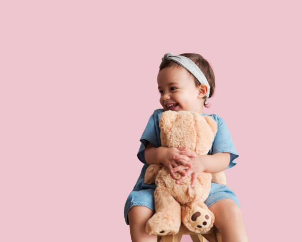 fröhliches kleinkind mit ihrem lieblingsspielzeug - vitality innocence clothing human age stock-fotos und bilder
