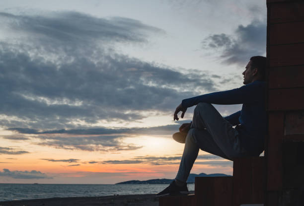 istock Man watching the sunset at sea 1158042974
