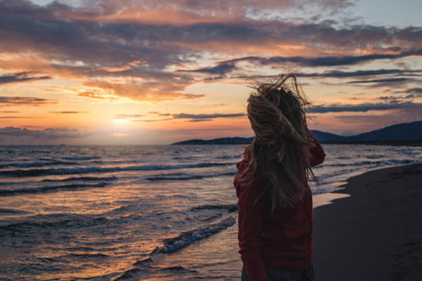 istock Girl on a windy beach in sunset 1158043064