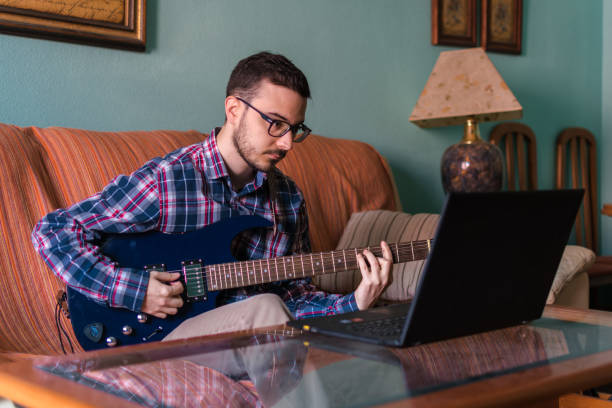 istock Man learn playing electric guitar at home 1158046810