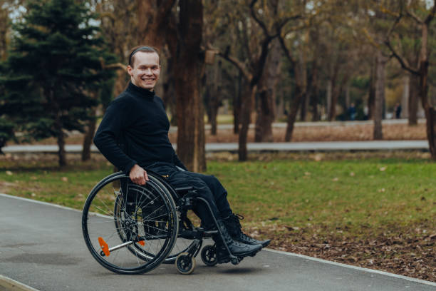 istock young disabled man in wheelchair walking park 1158046854