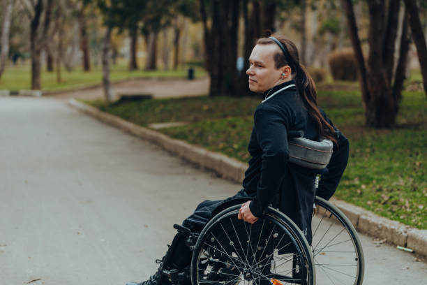istock young disabled man in wheelchair walking park 1158046890