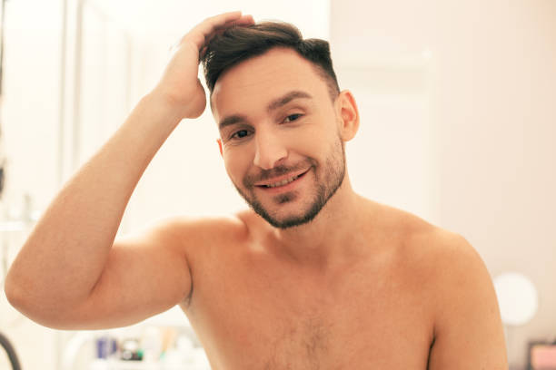 istock Positive man smiling and putting one hand on his head 1158047898