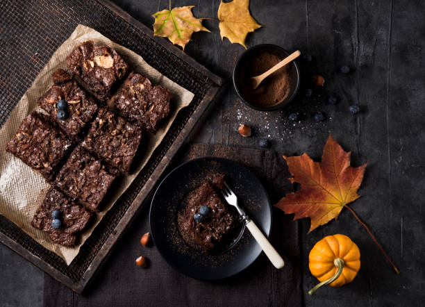 słodkie ręcznie czekoladowe brownie z jagodami dyni żółty folliage ciemne tło jesienny nastrój top view"n - nut pastry brownie hazelnut zdjęcia i obrazy z banku zdjęć