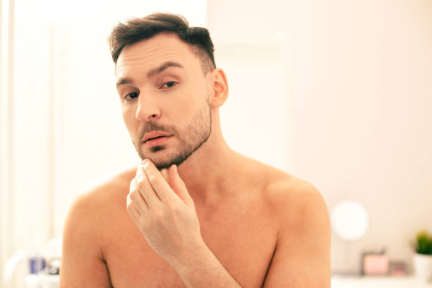 istock Curious man frowning and touching his unshaved beard 1158048092