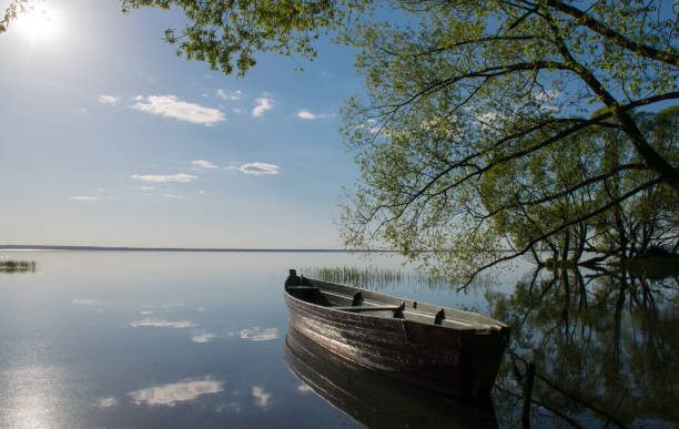 istock single boat on blue lake sun set  summer landscape nature evening 1158048413