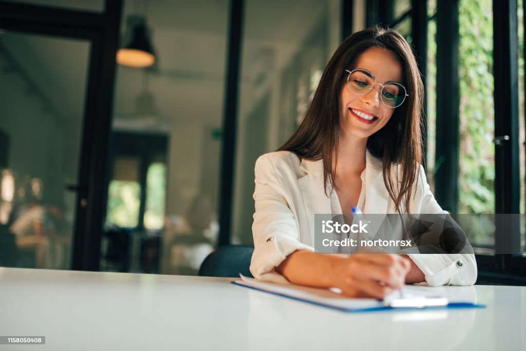 Motivated young woman hand filling application form. Signing Stock Photo