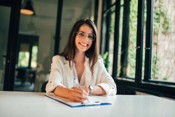 istock Portrait of elegant young woman completing application form. 1158050413