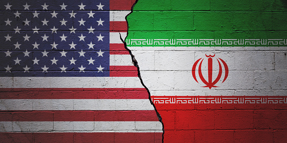 Cracked brick wall painted with an American flag on the left and a Iranian flag on the right.