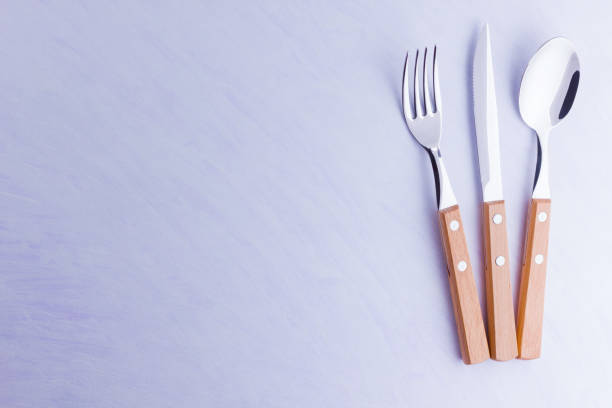 istock Set of cutlery: knife, fork, spoon on white background. Table setting. Concept of cutlery with wooden handles - laconic minimalistic design. Top view 1158060090