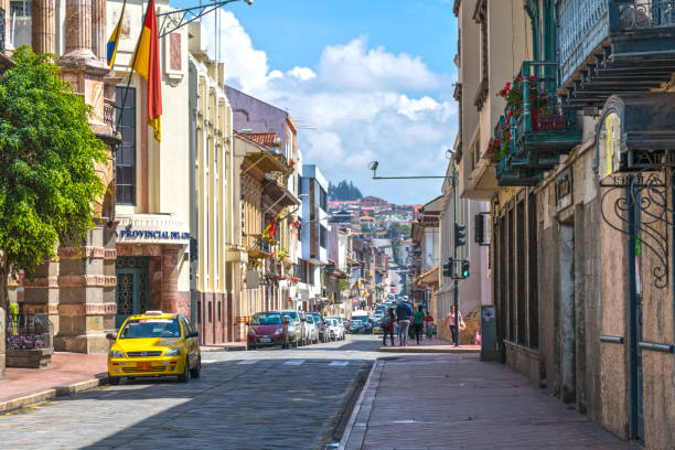 Street in Cuenca Cuenca, Ecuador - March 3, 2019: People and cars on old street in downtown district of Cuenca city. cuenca ecuador stock pictures, royalty-free photos & images
