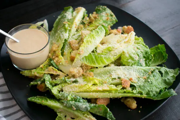 Caesar salad and dressing on a serving plate