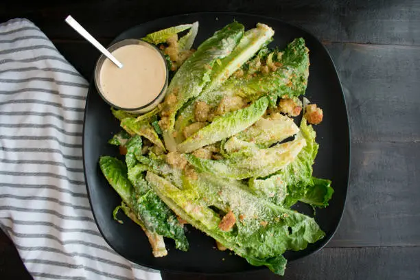 Caesar salad and dressing on a serving plate