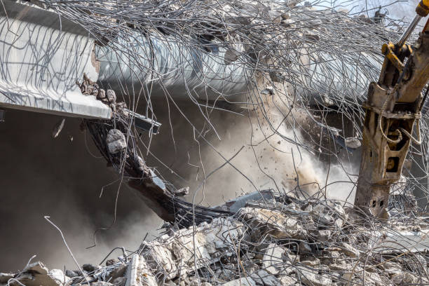 istock Professional demolition of reinforced concrete structures using industrial hydraulic hammer. Rods of metal fittings. Wreckage and crumbles of concrete. 1158061855
