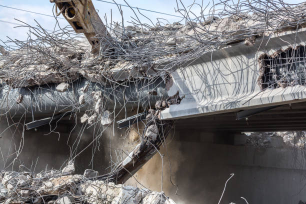 istock Professional demolition of reinforced concrete structures using industrial hydraulic hammer. Rods of metal fittings. Wreckage and crumbles of concrete. 1158061859