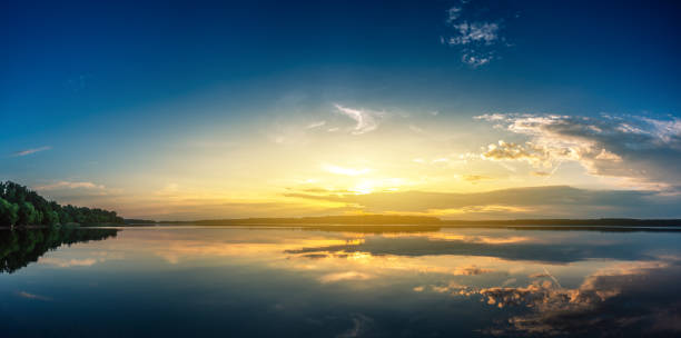 panoramaaufnahme des sonnenaufgangs über dem see - season lake cloudscape horizon stock-fotos und bilder