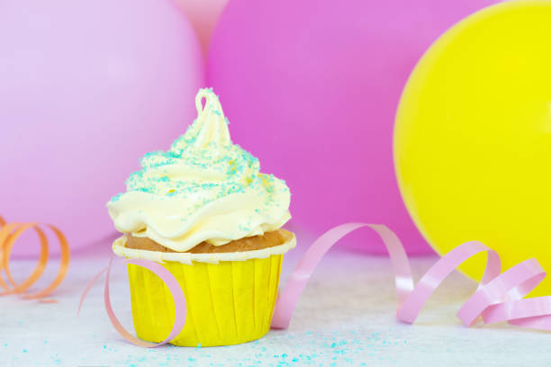 Birthday cupcake with decoration and balloons, festive composition