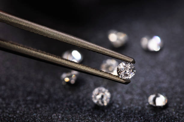istock Small diamond in tweezers, close-up 1158063889