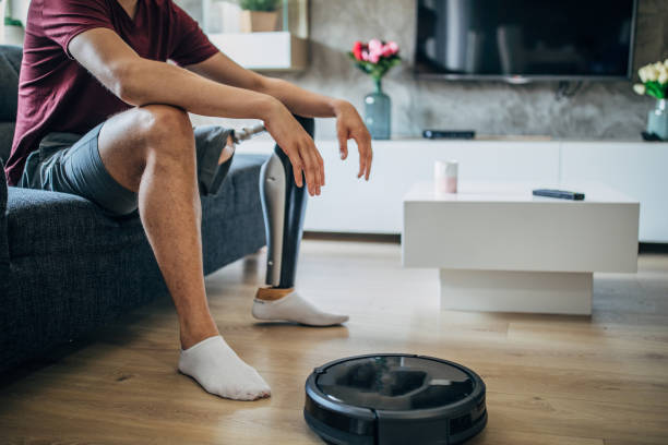 istock Young man with prosthetic leg sitting on sofa 1158066602