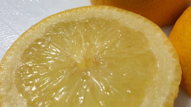istock Slice on lemon in close-up on white background 1158068059