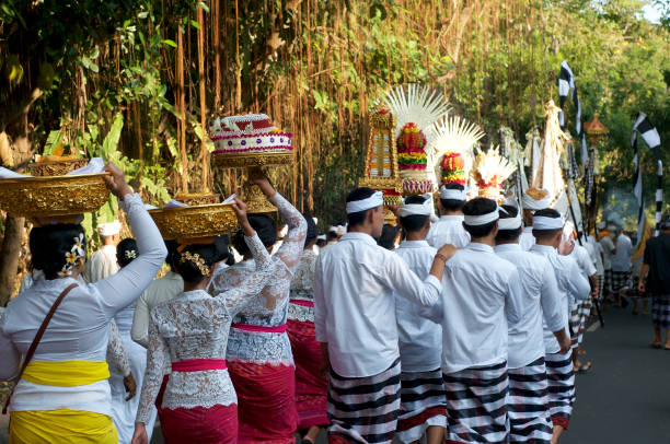 Ubud, Indonesia - April 13, 2012: The local  people at traditional Hindu ceremony at Ubud at island Bali in Indonesia. The man carring the gifts to the spirits on April 13, 2012.