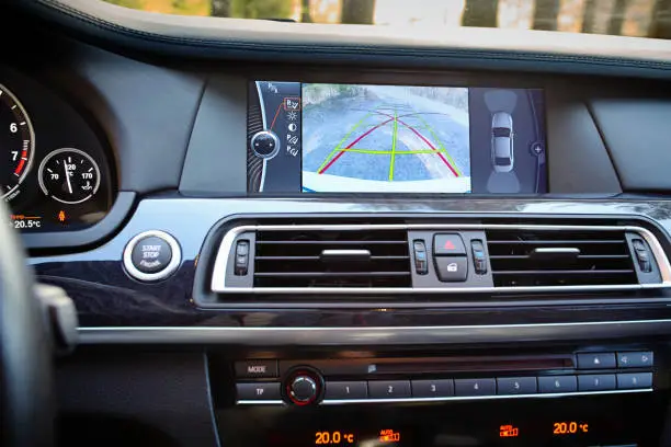 Photo of Interior of premium car with rearview camera dynamic trajectory turning lines and parking assistant. Driver assistance system for parking