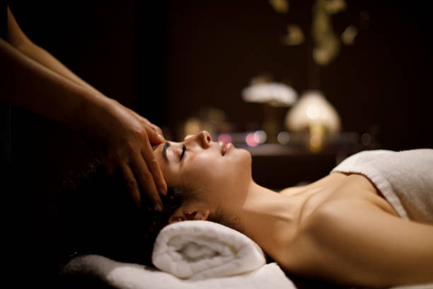 mujer disfrutando de masaje de cabeza en el centro de spa - head massage massaging facial massage beautician fotografías e imágenes de stock