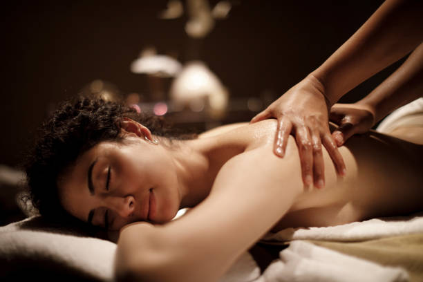 young woman enjoying massage - massaging massage therapist rear view human hand imagens e fotografias de stock