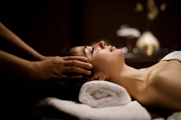 mujer disfrutando de masaje de cabeza en el centro de spa - head massage massaging facial massage beautician fotografías e imágenes de stock
