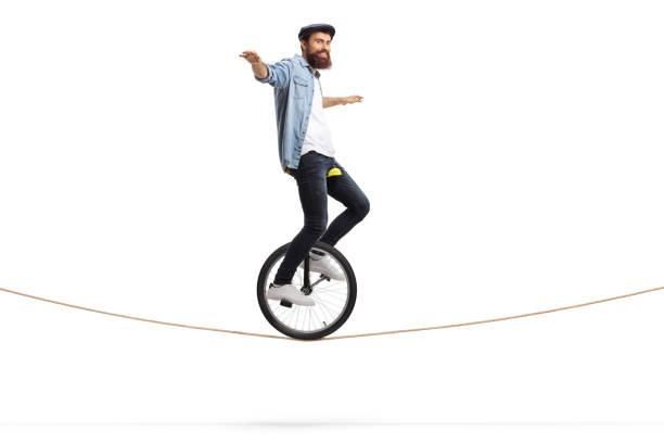 homme conduisant un monocycle sur une corde et équilibrant avec ses mains - unicycling photos et images de collection