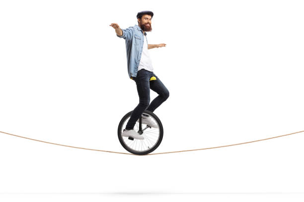 человек верхом на одноколесном велосипеде на веревке и балансировки руками - unicycle стоковые фото и изображения