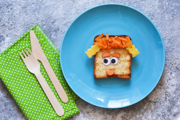 istock Funny faces - lunch for the child. Sandwich with vegetables. View from above. 1158070294