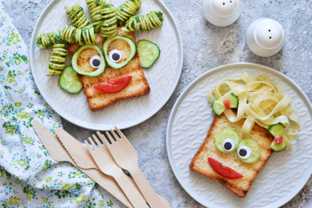 istock Funny faces - lunch for the child. Sandwich with vegetables. View from above. 1158070317