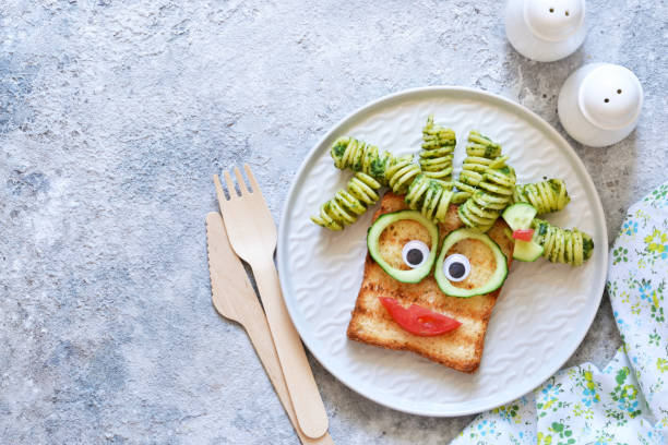 istock Funny faces - lunch for the child. Sandwich with vegetables. View from above. 1158070356