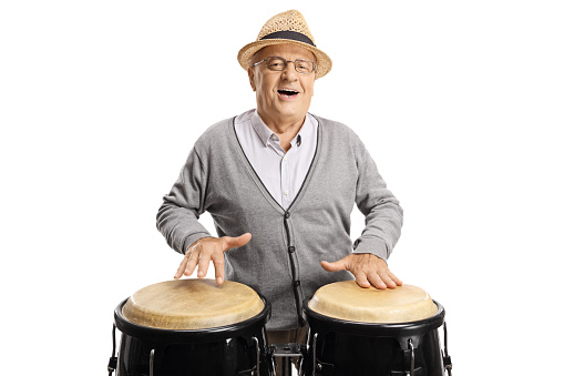 Cheerful elderly man playing conga drums isolated on white background