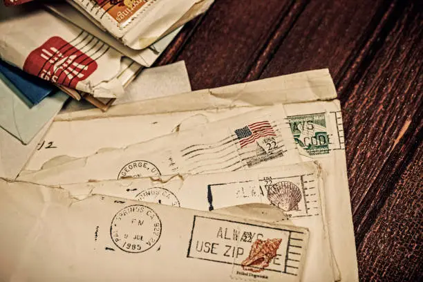 Stack of old letters in envelopes mailed from Palm Springs, California and St. George, Utah in 1985 with postmarks and cancelled postage stamps.