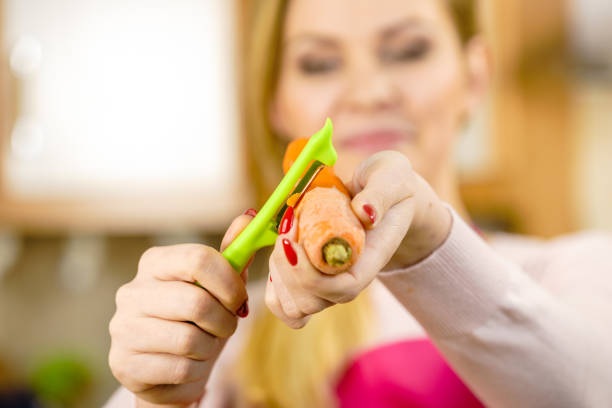 istock Woman peeling carrot vegetable 1158070750