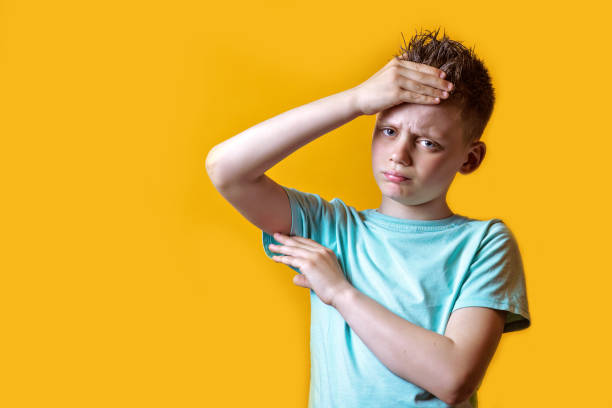 istock a boy in a light t-shirt got sick and feels bad on a colored background 1158071504