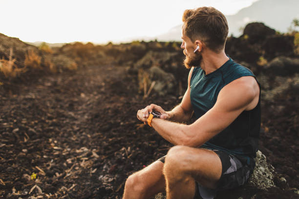 istock Athletic runner start training on fitness tracker or smart watch and looking forward on horizon. Trail running and active lifestyle concept. 1158072971