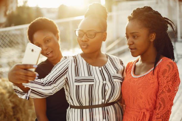 istock Beautiful black girls standing in a sumer park 1158078270