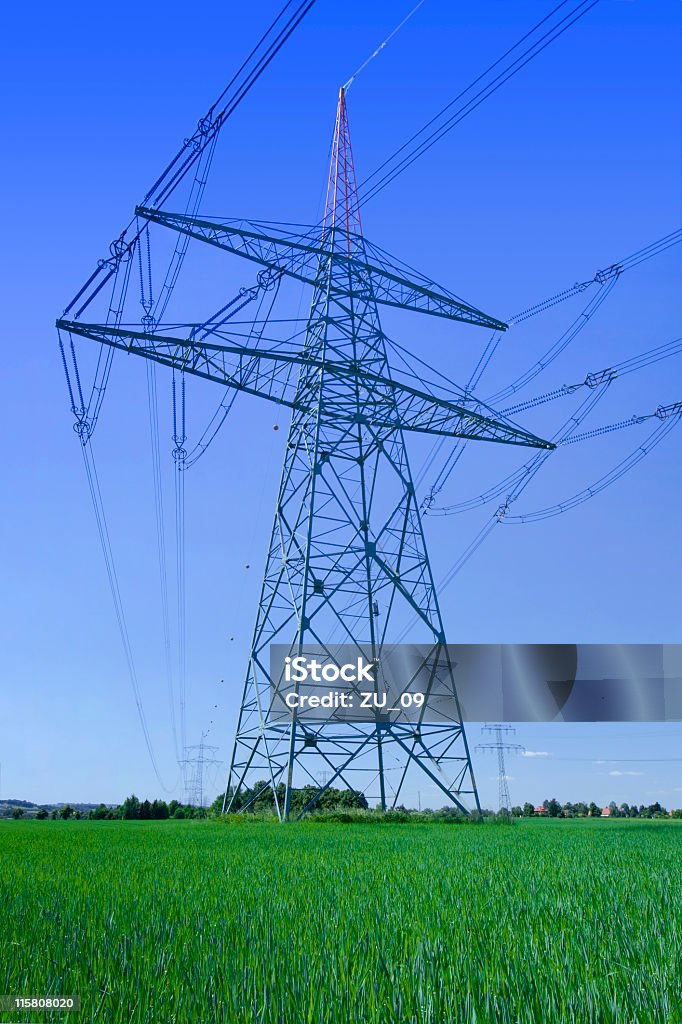 Hochspannungsmast auf einem grünen Feld - Lizenzfrei Achtung Hochspannung Stock-Foto